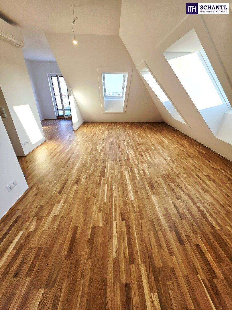 Heller Raum im Dachgeschoss mit Holzboden und großen Dachfenstern, bereit zur Einrichtung.