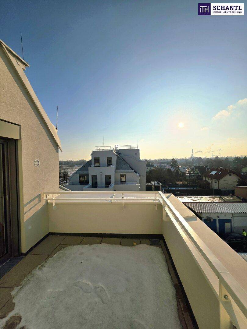 Dachterrasse mit weitem Blick über die Stadt und angrenzende Gebäude, sonnig und hell.