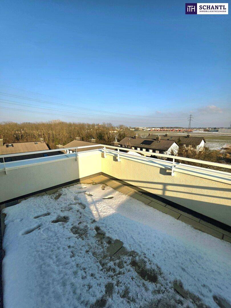 Dachterrasse mit weitem Blick über die Landschaft und Spuren im Schnee, sonniger Tag.