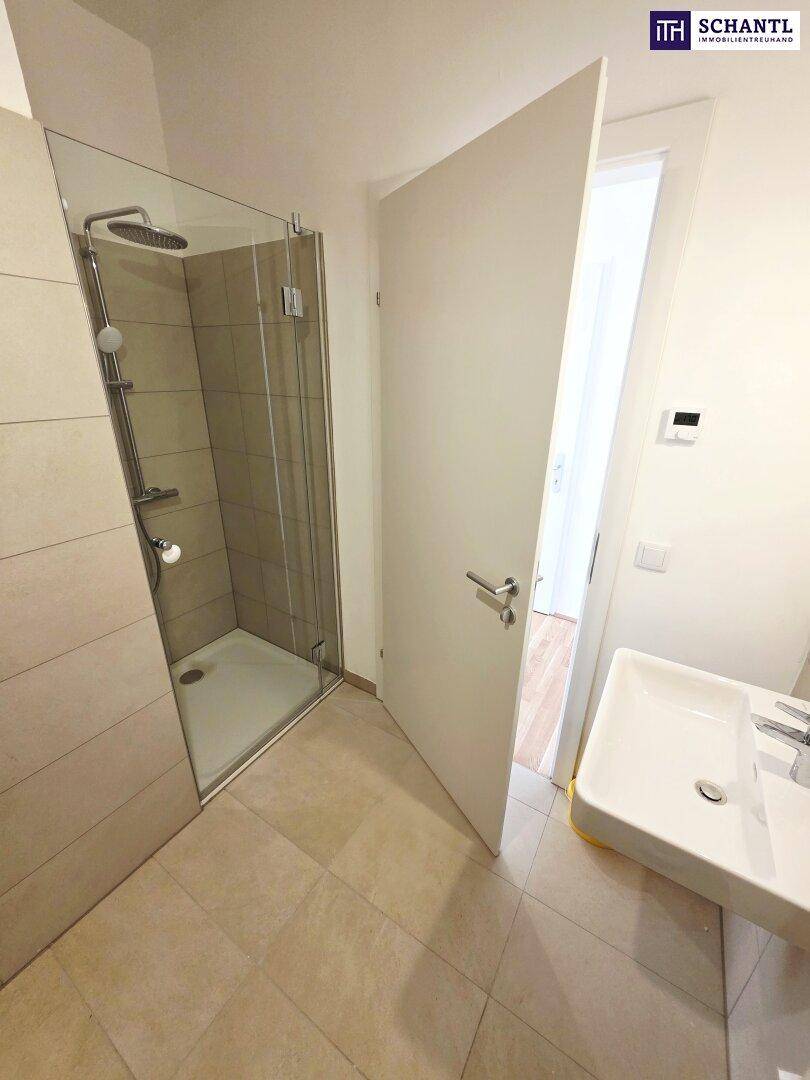 Modernes Badezimmer mit ebenerdiger Dusche, Waschbecken und Fliesenboden.