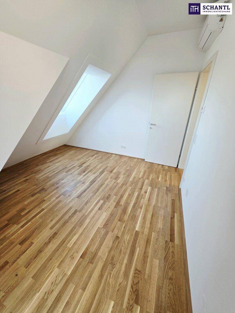Geräumiger Raum im Dachgeschoss mit Holzboden und Dachfenster, bietet viel Tageslicht.