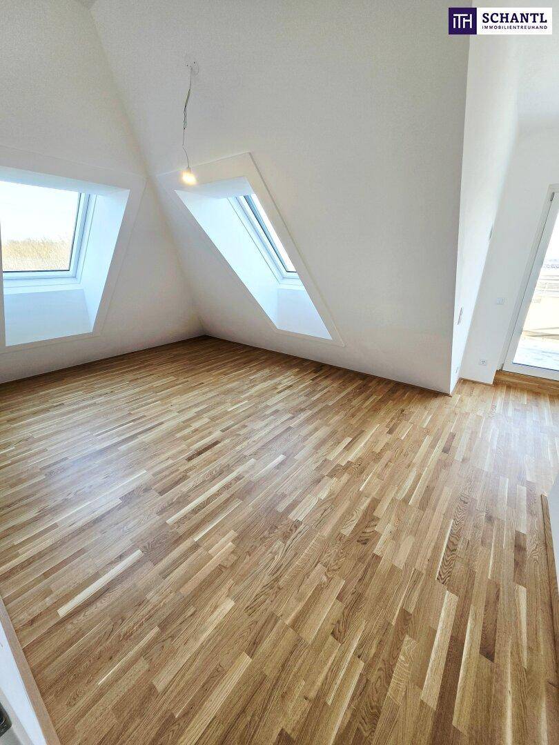 Lichtdurchfluteter Dachgeschossraum mit Holzboden und mehreren Dachfenstern, bereit zur Gestaltung.