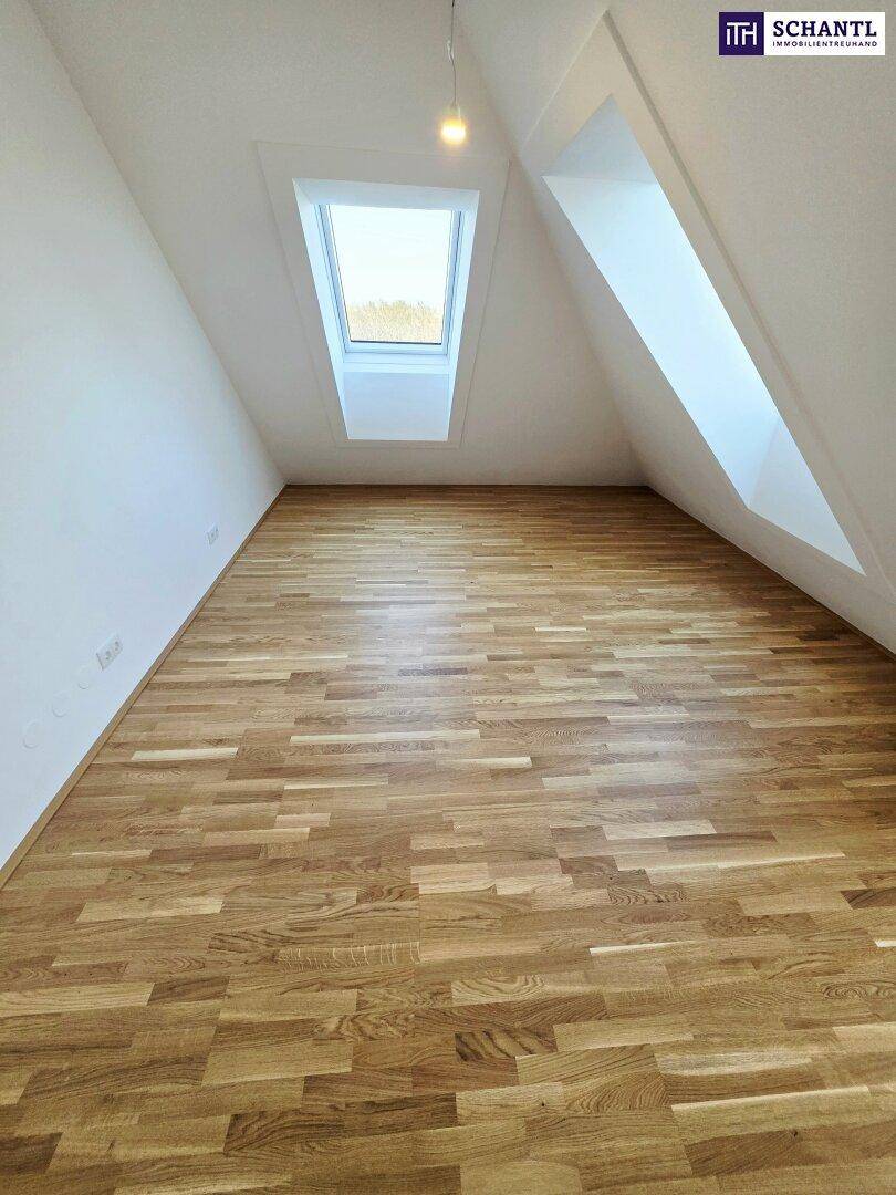 Heller Raum im Dachgeschoss mit Holzboden und großem Dachfenster, bietet viel Tageslicht.