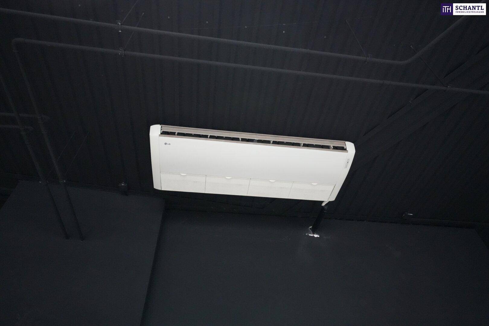 Deckenmontierte Klimaanlage in einem Gewerberaum mit dunkler Decke, sorgt für angenehme Raumtemperatur.