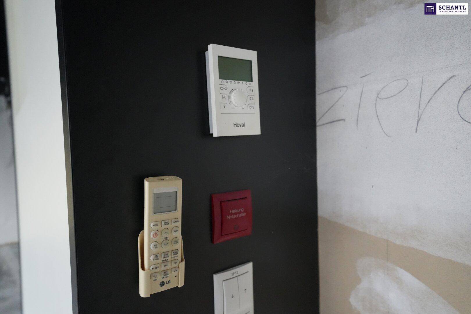 Wandmontierte Steuerungselemente für Heizung und Klimaanlage in einem Gewerberaum, inklusive Fernbedienung.