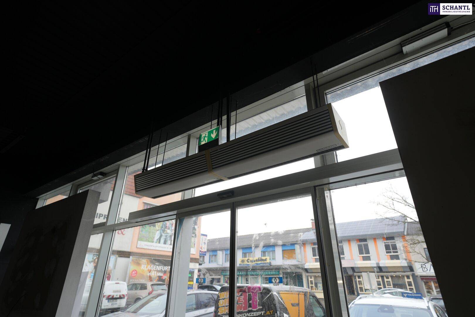 Deckenmontierte Heiz- oder Kühleinheit über dem Eingangsbereich, mit Blick auf die Straße durch die Fenster.