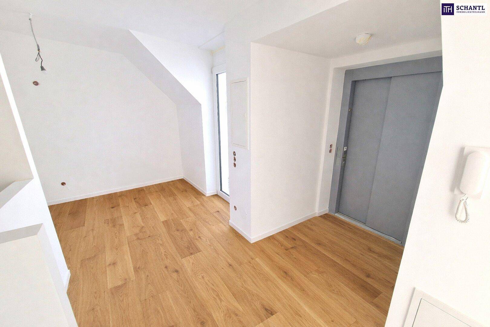 Heller Flur mit Holzboden und Zugang zu einem modernen Aufzug, der die oberen Etagen erschließt.
