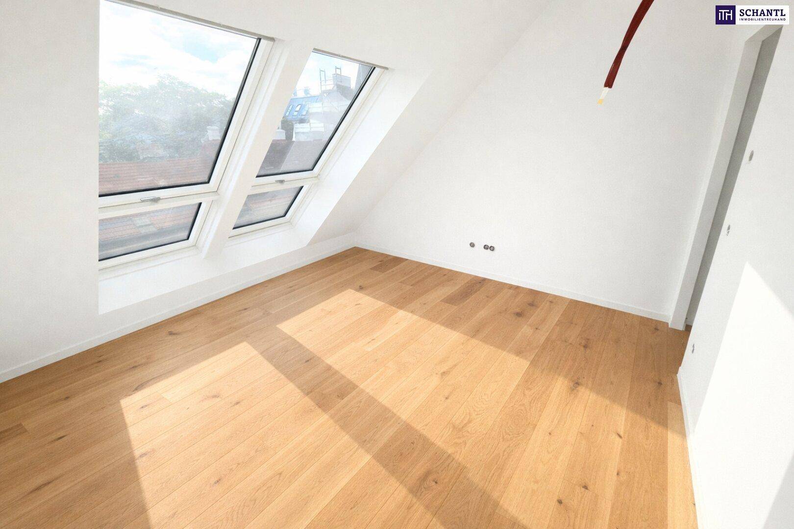 Heller Raum mit Holzboden und Dachfenstern, die viel natürliches Licht in den Dachgeschossbereich bringen.
