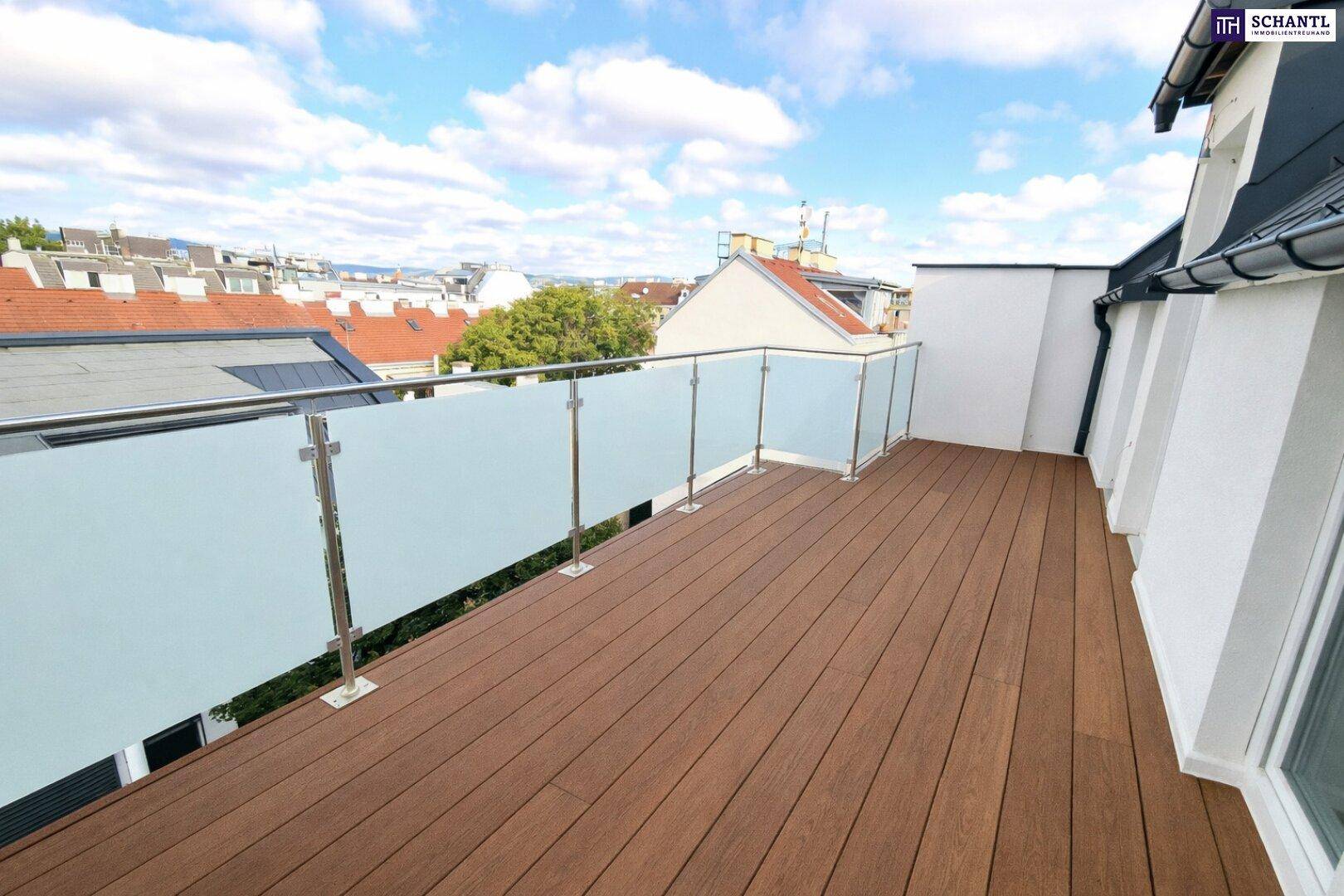 Moderne Dachterrasse mit Holzboden und Glasgeländer, bietet einen weiten Blick über die Stadt.