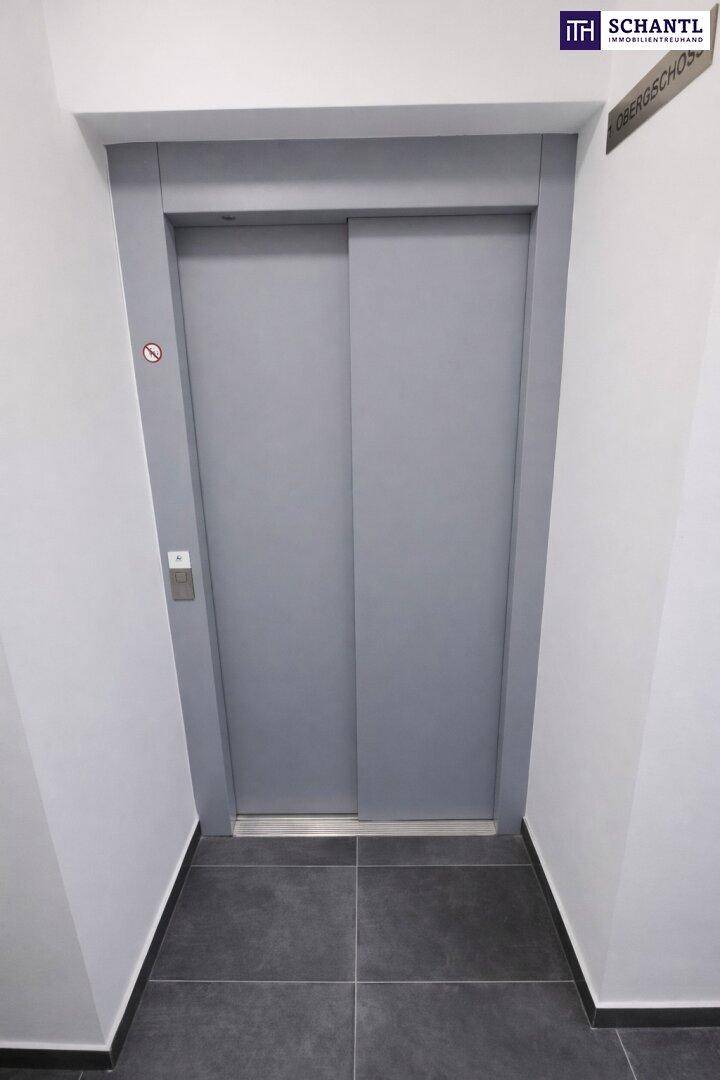 Moderner Aufzug mit grauen Türen und gefliestem Boden in einem sauberen und funktionalen Gemeinschaftsbereich.