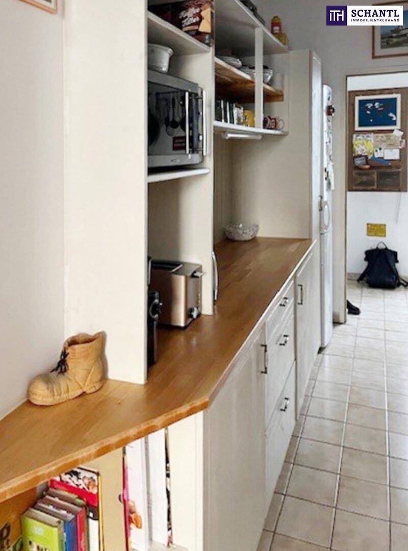 Küchenzeile mit Holz-Arbeitsplatten, offenen Regalen und integrierten Geräten in hellem Design.