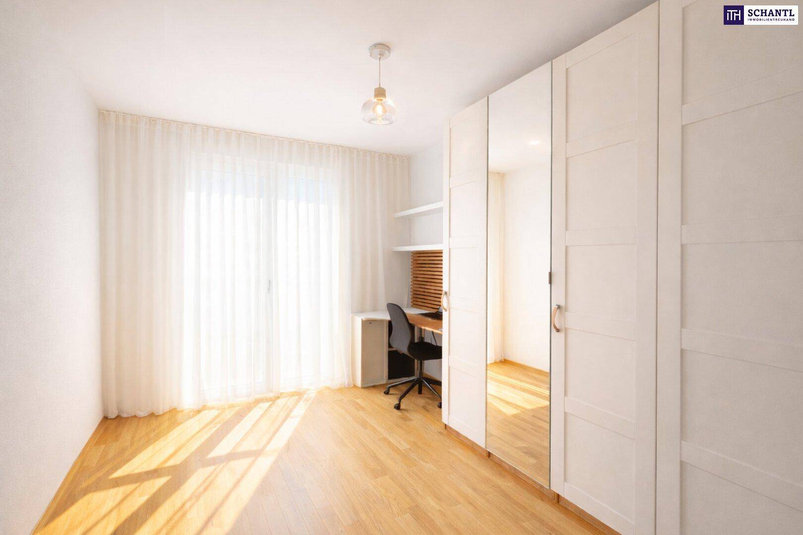 Helles Schlafzimmer mit Holzboden, großem Fenster und integriertem Spiegelschrank.