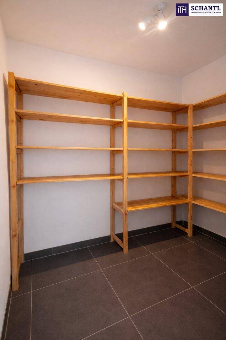 Praktischer Abstellraum mit robusten Holzregalen und Fliesenboden für zusätzlichen Stauraum.