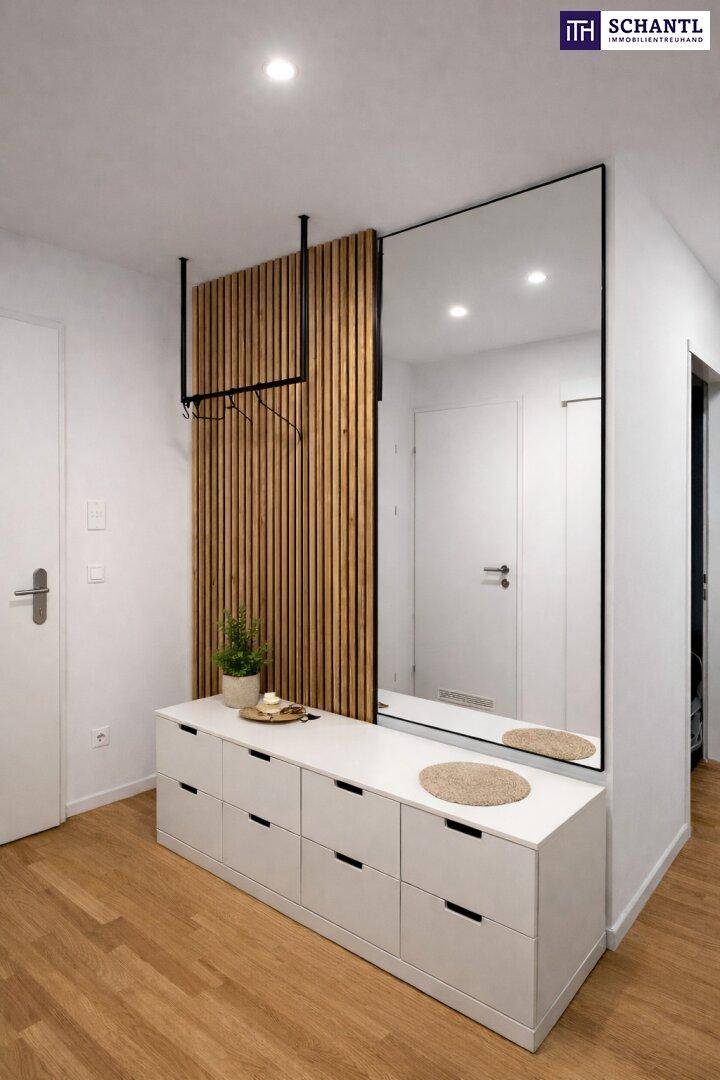 Moderner Eingangsbereich mit Holzboden, großem Spiegel und praktischer Garderobe.