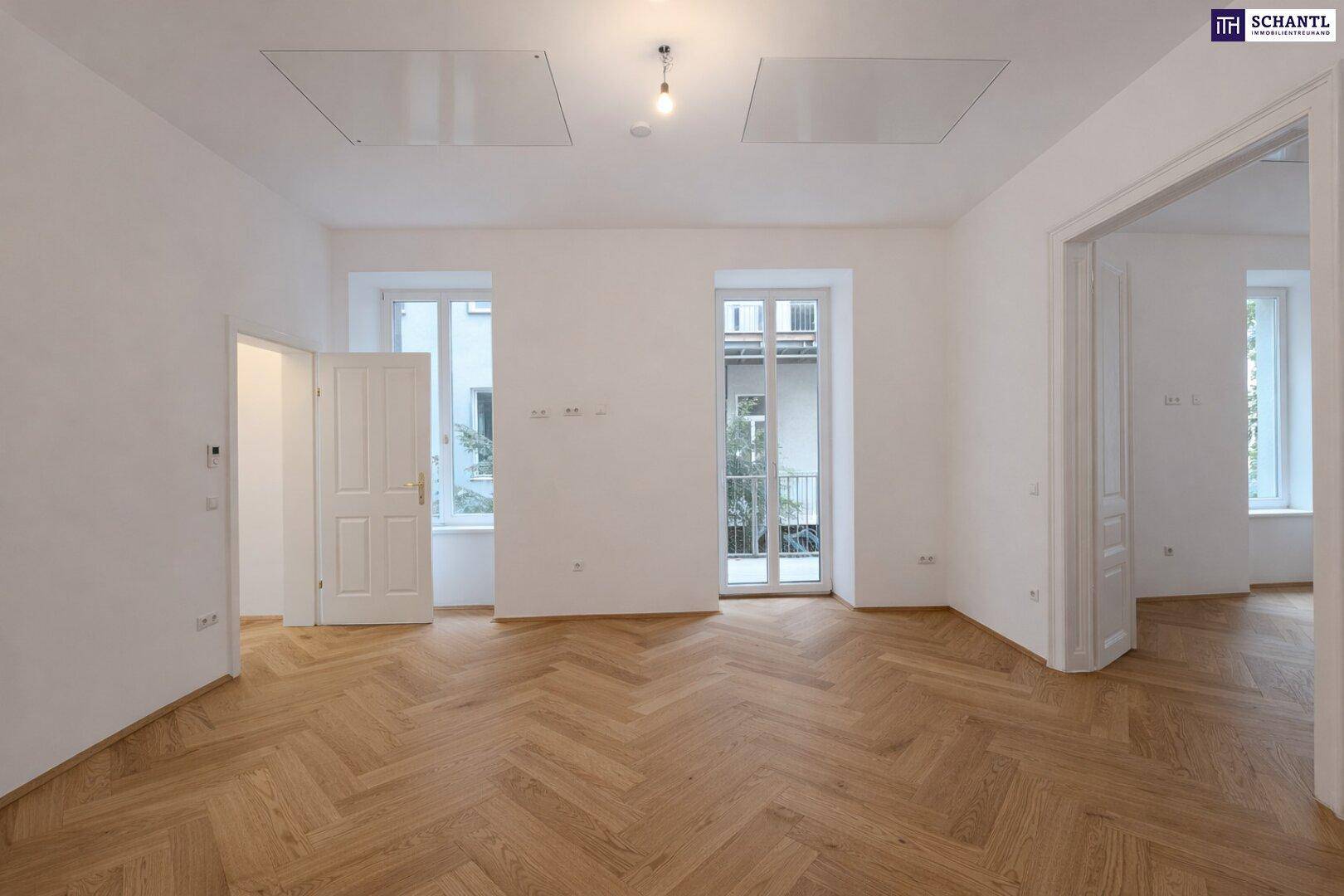 Geräumiger Wohnbereich mit elegantem Fischgrätparkett und großen Fenstern für viel Tageslicht und frische Luft.
