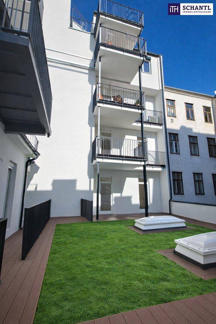 Gemeinschaftsgarten mit Rasenfläche und angrenzenden Balkonen, umgeben von Gebäuden.