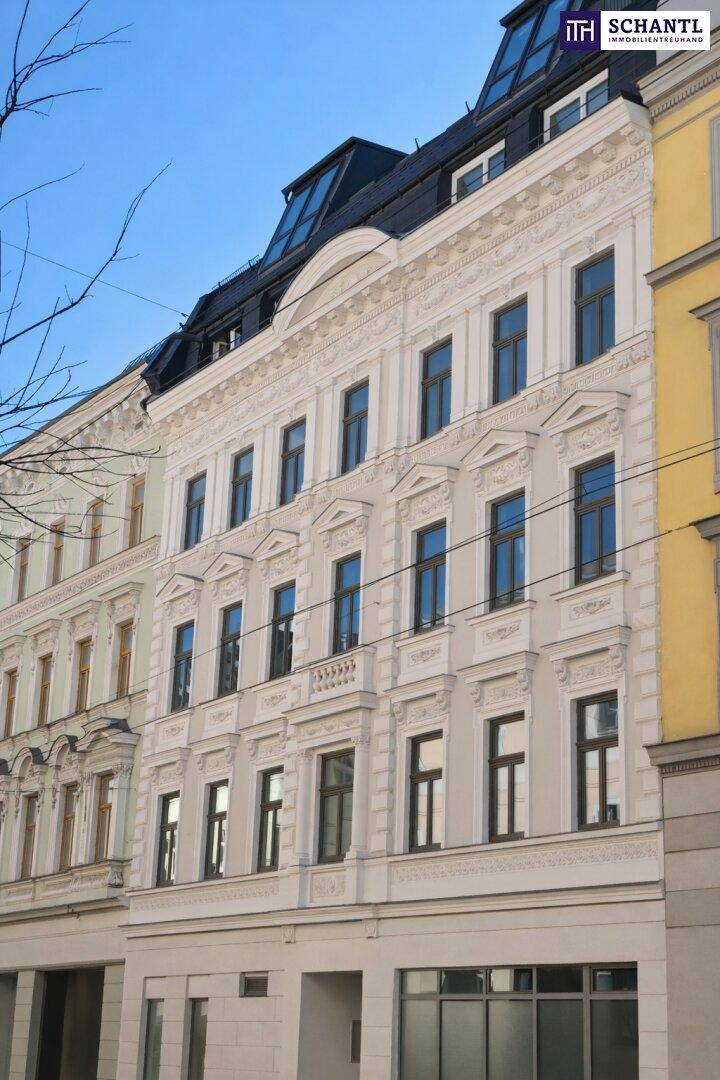 Historische Fassade eines sanierten Gebäudes mit vielen Fenstern und Mansarddach.