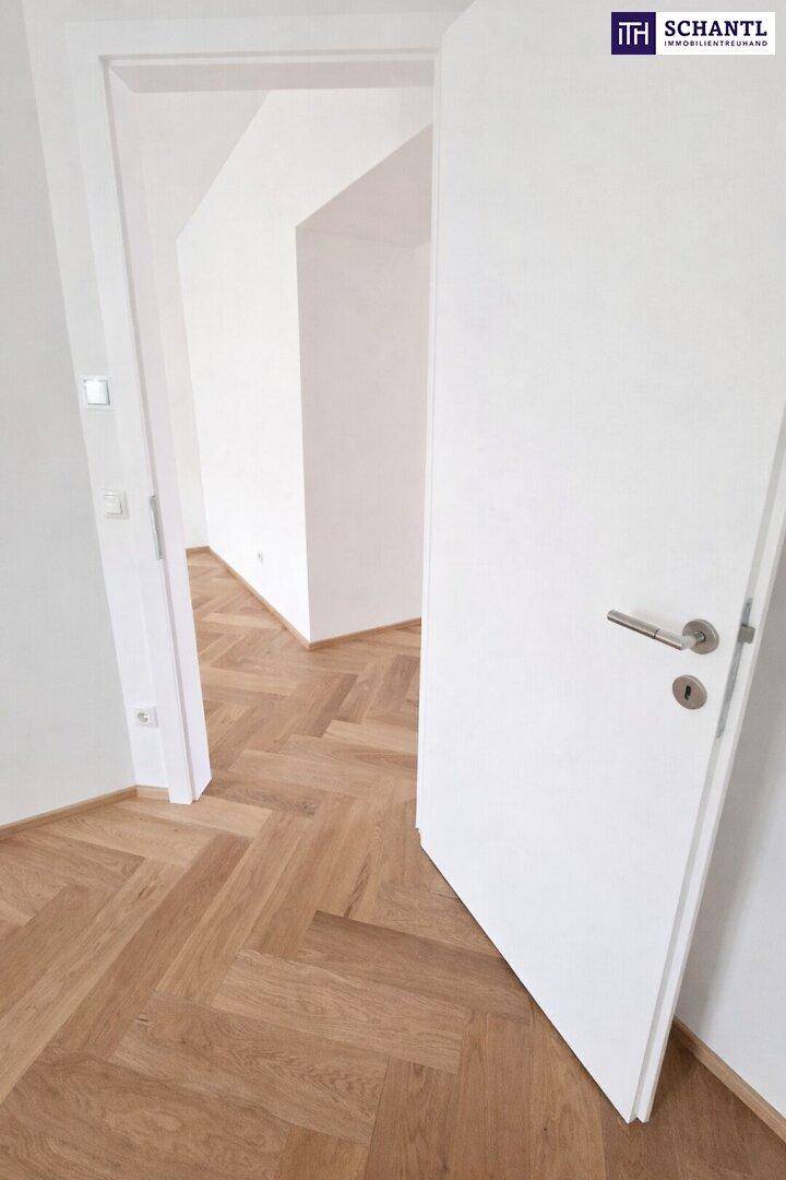 Offener Flurbereich mit Fischgrätparkett und weißen Türen, verbindet verschiedene Zimmer.