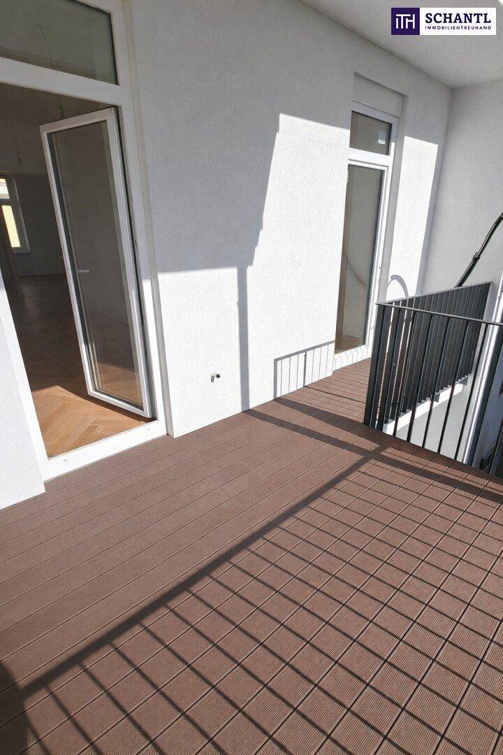 Geräumiger Balkon mit Holzdielen und Zugang zu den Innenräumen, sonnig und hell.