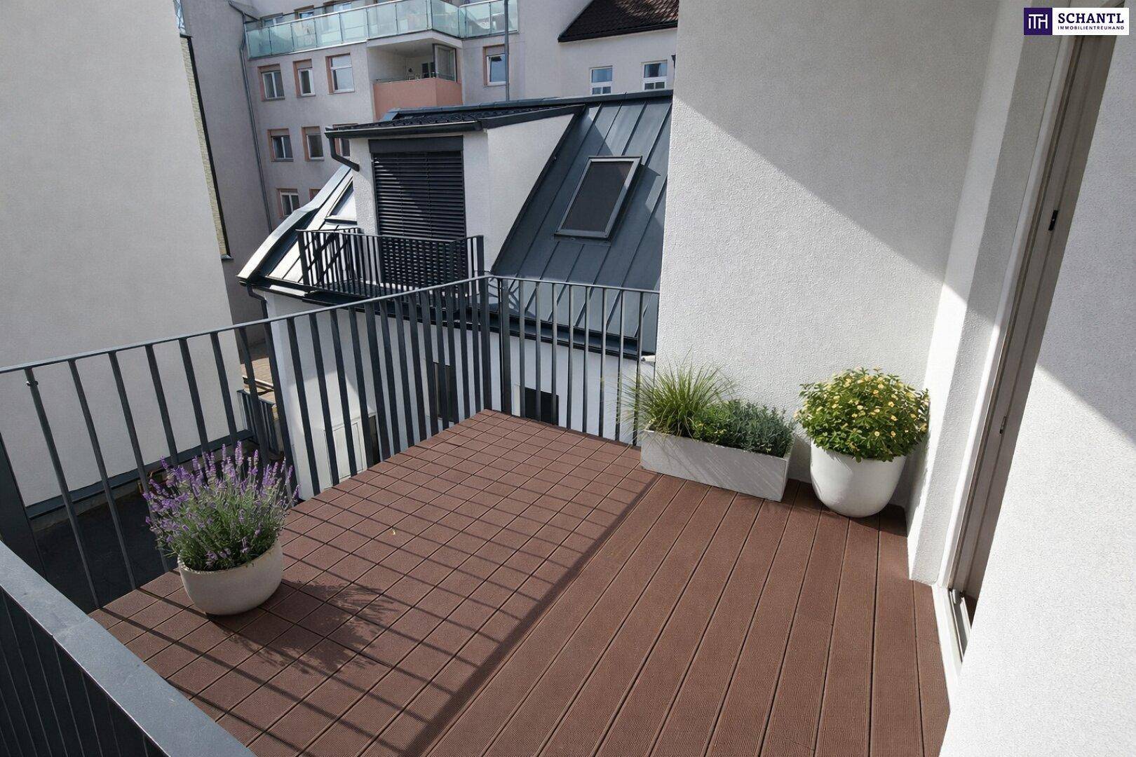 Kleiner Balkon mit Holzdielen und Pflanzen, bietet einen ruhigen Außenbereich.