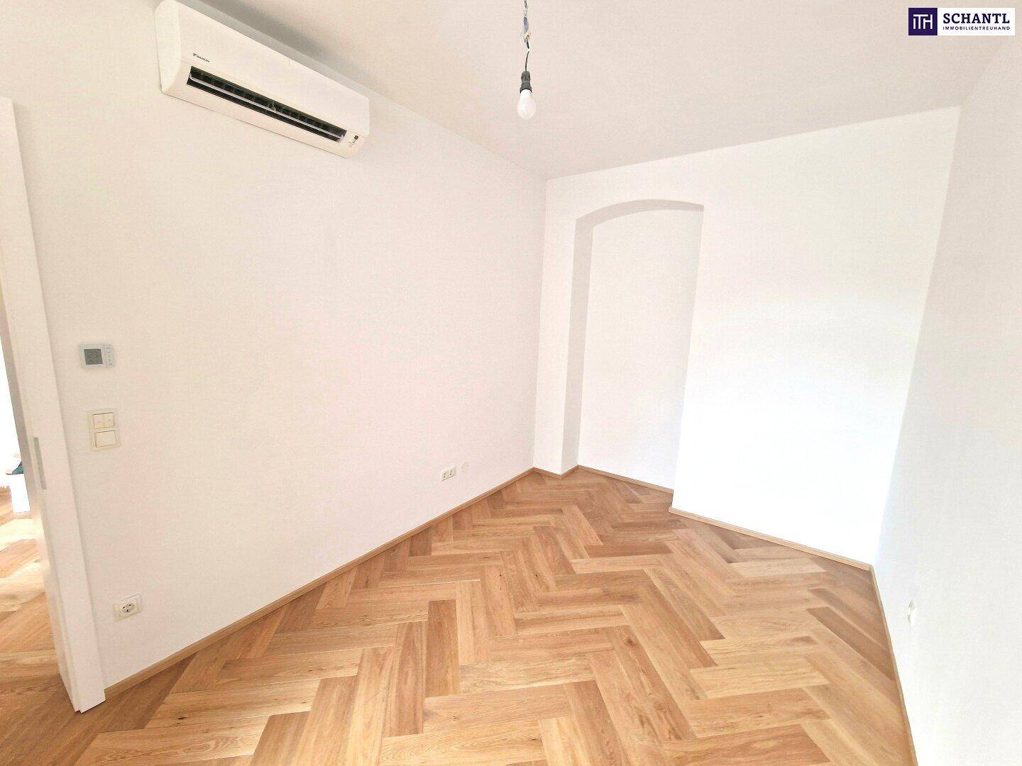 Heller Raum mit Fischgrätparkett und Klimaanlage, ideal als Wohn- oder Schlafzimmer.