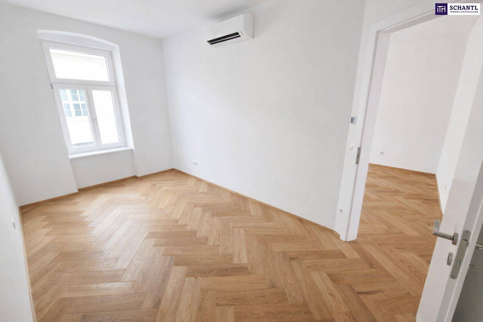 Helles Zimmer mit Fischgrätparkett, Klimaanlage und einem Fenster, bereit zur Nutzung.