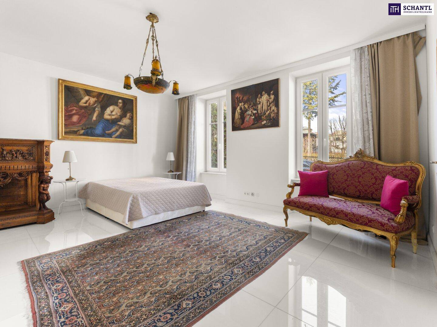 Geräumiges Schlafzimmer mit großen Fenstern, antiken Möbeln und einem orientalischen Teppich.