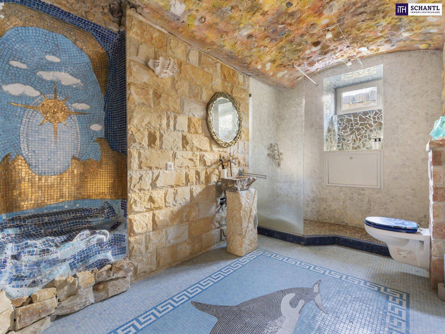 Einzigartiges Badezimmer mit aufwendigen Mosaikfliesen, Steinwänden und einem kunstvollen Waschbecken.