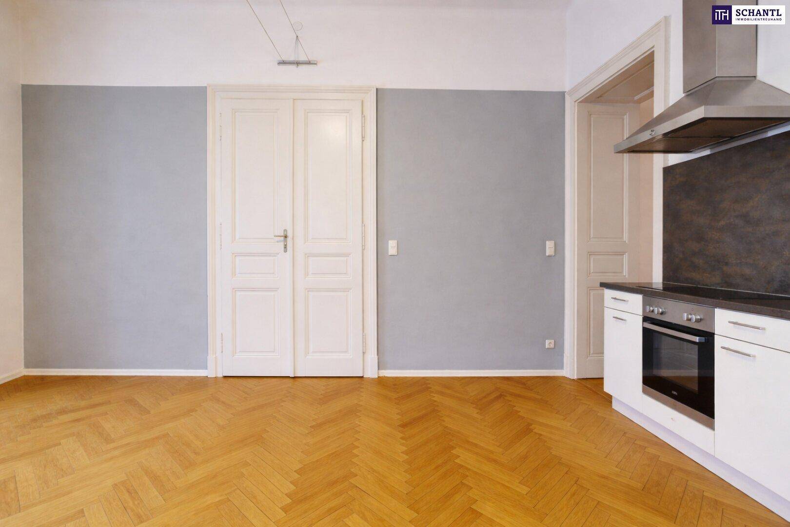 Detailansicht der Küchenzeile mit Backofen, Dunstabzugshaube und weißen Unterschränken.