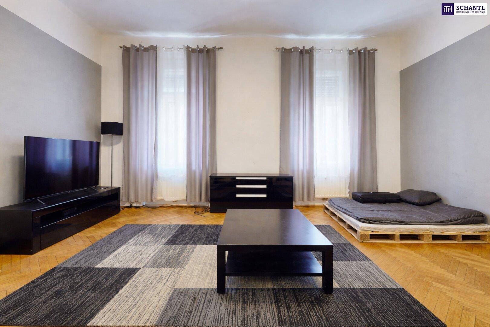 Helles Wohnzimmer mit Holzboden, modernem Teppich und einem niedrigen Couchtisch.