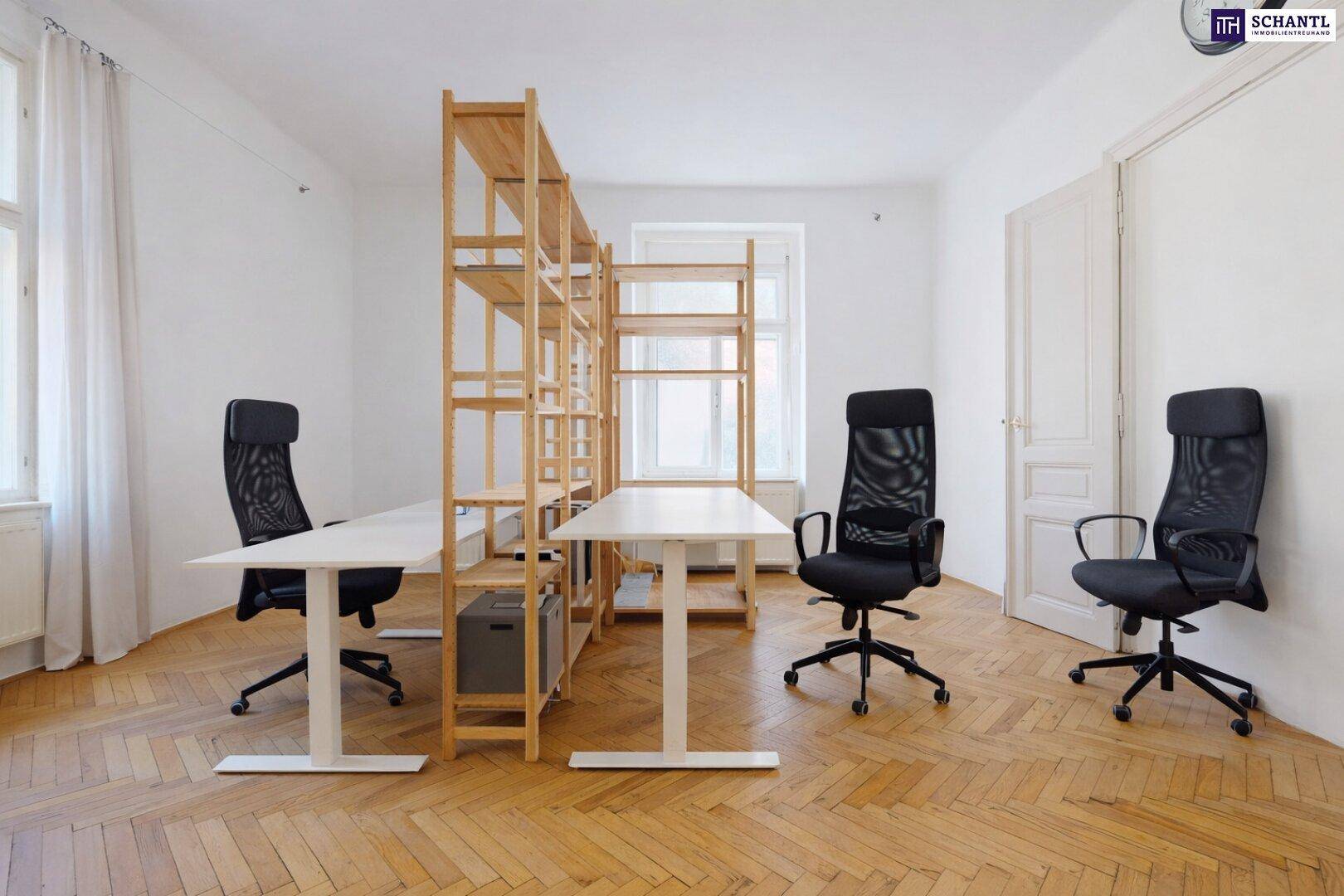 Helles Büro mit mehreren Arbeitsplätzen, Holzregalen und klassischem Fischgrätparkett.