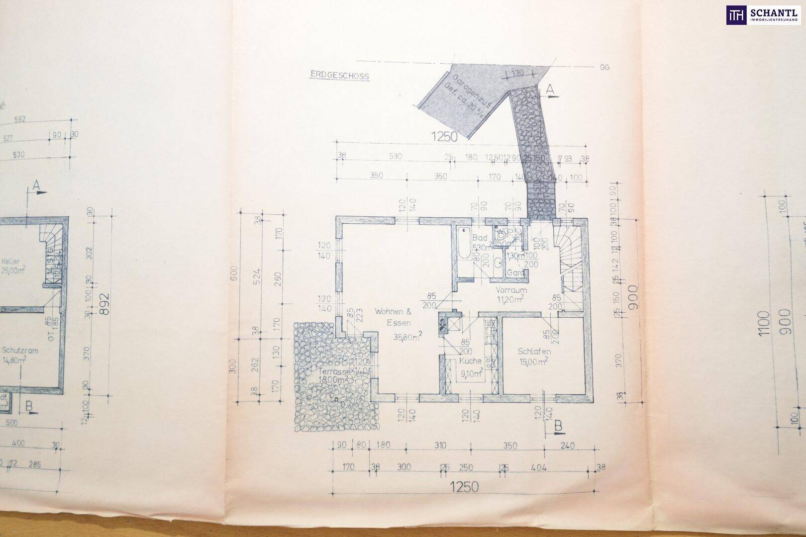 Grundriss des Erdgeschosses mit Wohn- und Essbereich, Küche, Schlafzimmer und Zugang zur Terrasse.