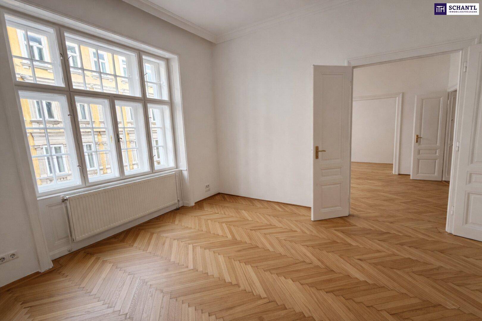 Geräumiger, leerer Raum mit Fischgrätparkett und großen Fenstern, ideal für Wohnen oder Schlafen.