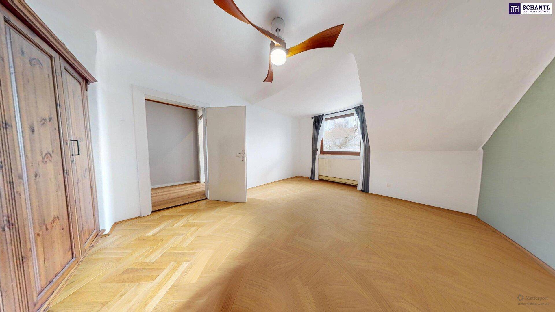 Leeres Schlafzimmer mit Parkettboden, Dachschräge und Deckenventilator.