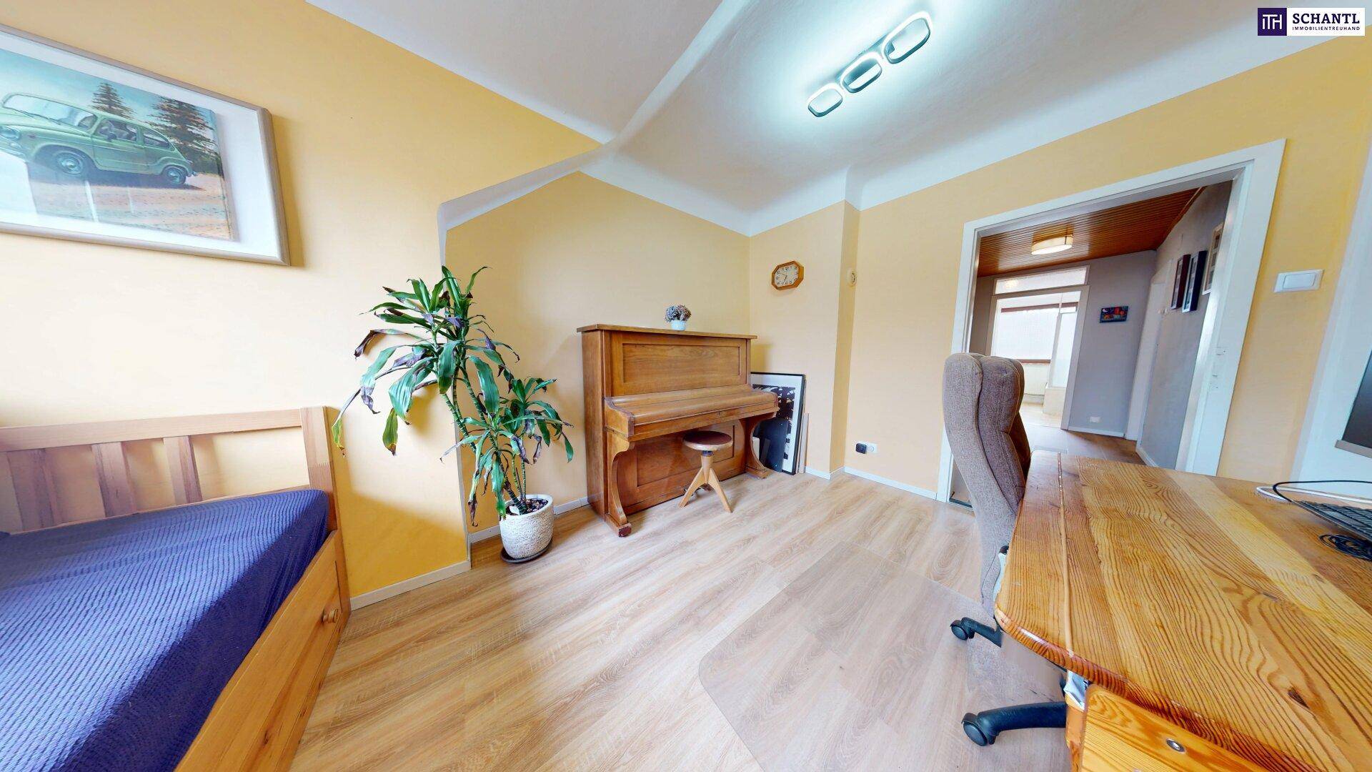 Arbeitszimmer mit Holzboden, Klavier und Schreibtisch.