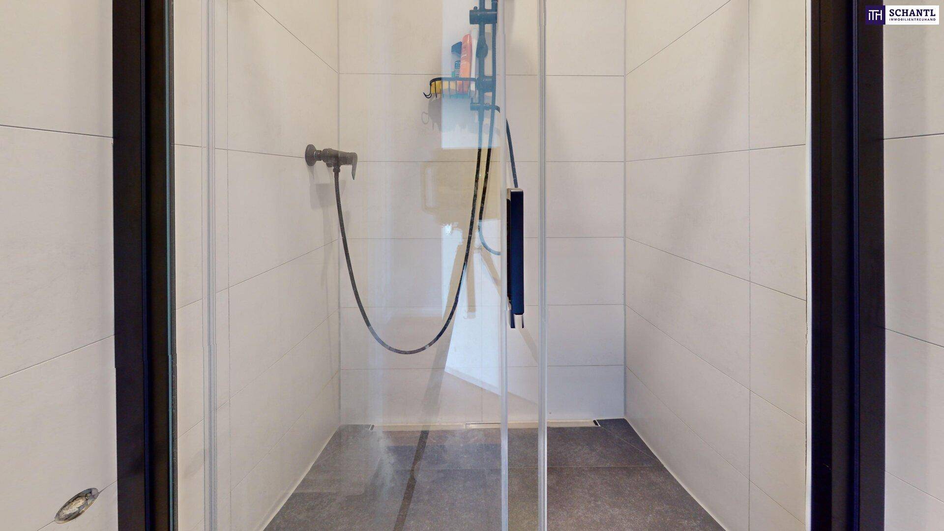 Moderne Duschkabine mit Fliesen in hellen und dunklen Grautönen.
