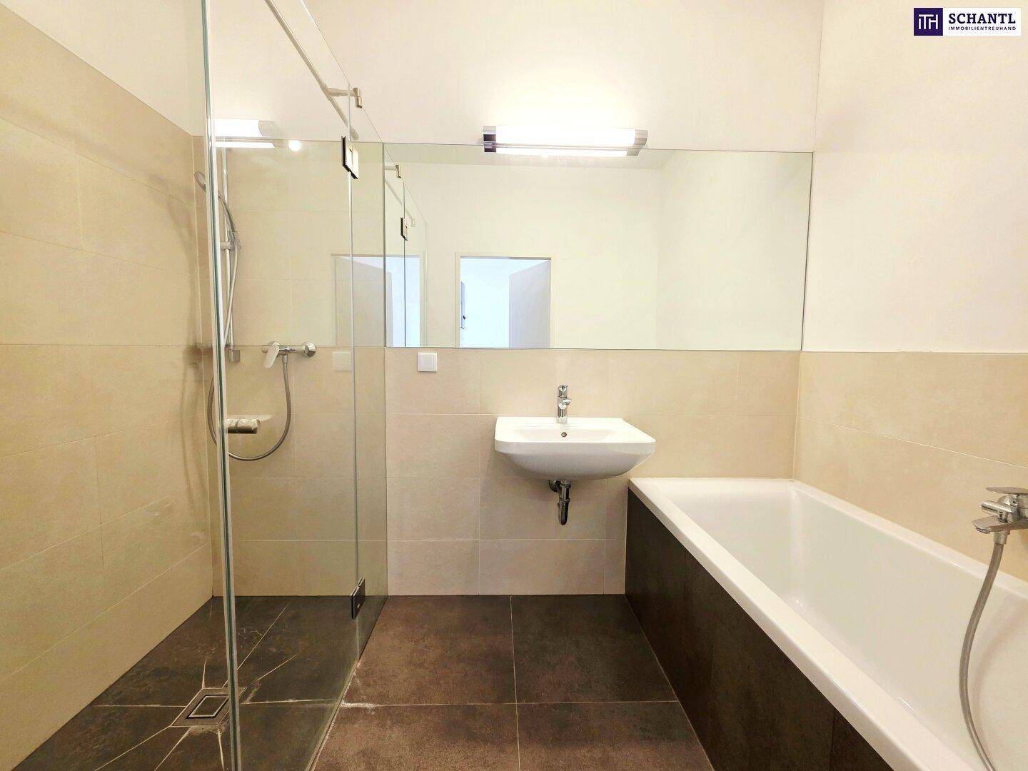 Modernes Badezimmer mit Badewanne, Duschbereich und großem Spiegel.