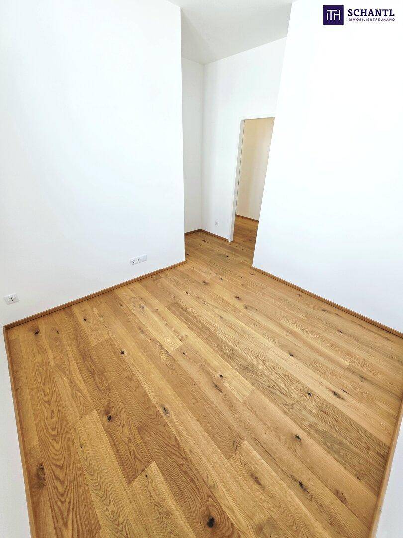 Leerer Raum mit hellem Holzboden und weißen Wänden, bereit zur individuellen Gestaltung.