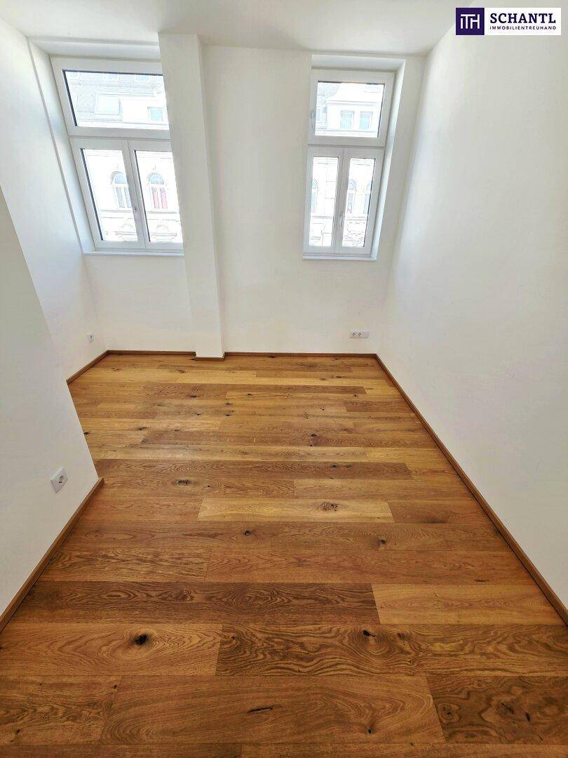 Unmöblierter Raum mit Holzboden und zwei Fenstern, ideal für ein Kinderzimmer oder Büro.