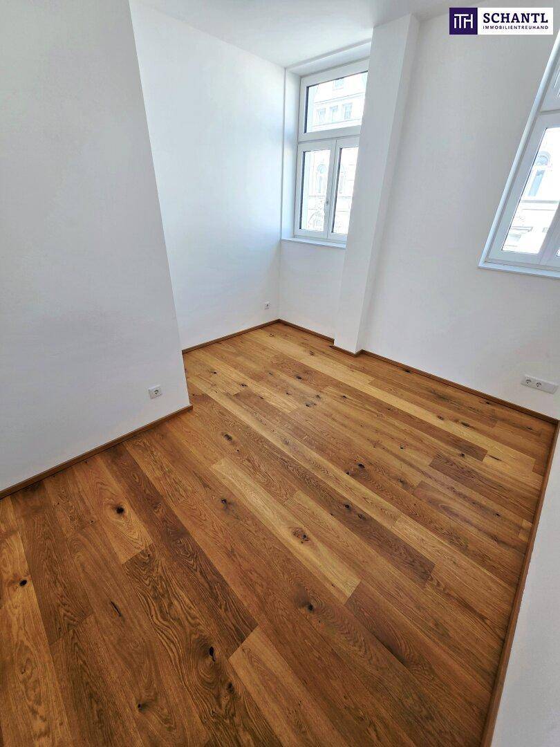 Heller Raum mit Holzboden und zwei Fenstern, bietet viel Tageslicht.
