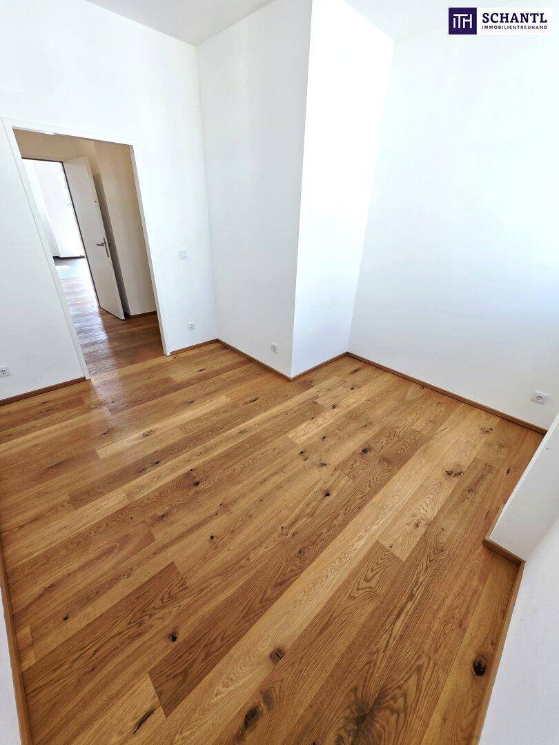 Unmöblierter Raum mit warmem Holzboden und weißen Wänden, ideal für ein Schlafzimmer.