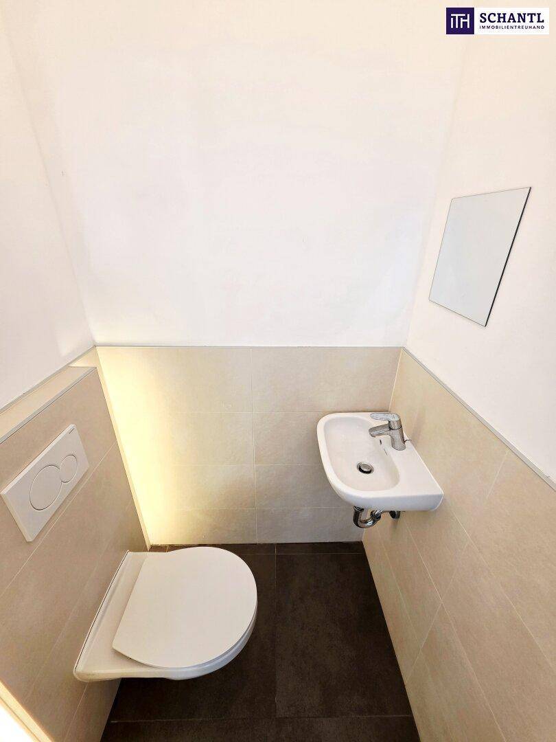 Modernes Gäste-WC mit wandhängendem WC und kleinem Waschbecken.