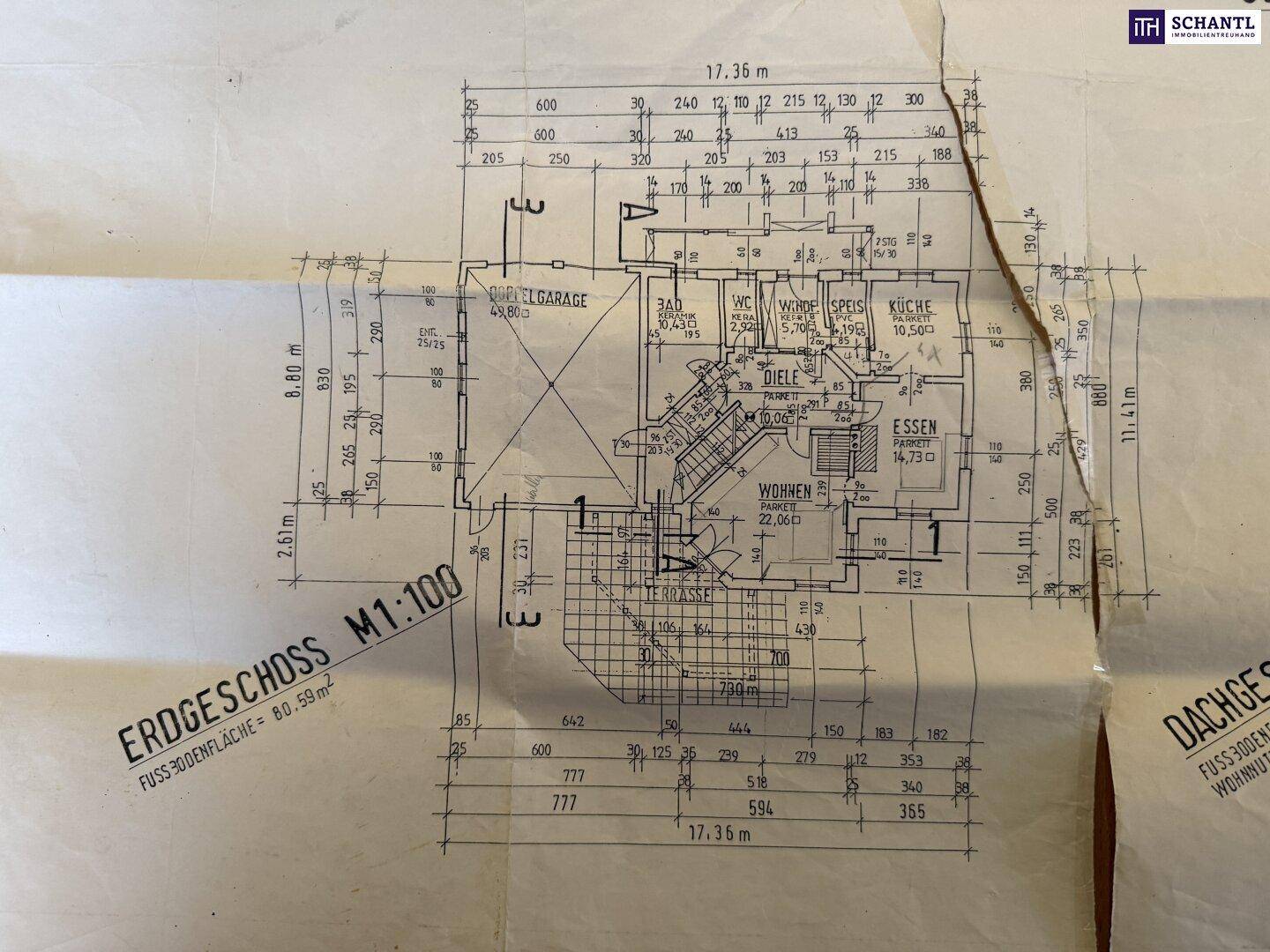 Grundriss des Erdgeschosses mit offenem Wohnbereich, Küche, Garage und Terrasse.