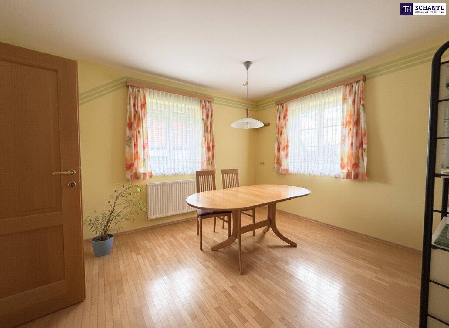 Gemütliches Esszimmer mit Holztisch, Stühlen und Parkettboden, ideal für Familienmahlzeiten.