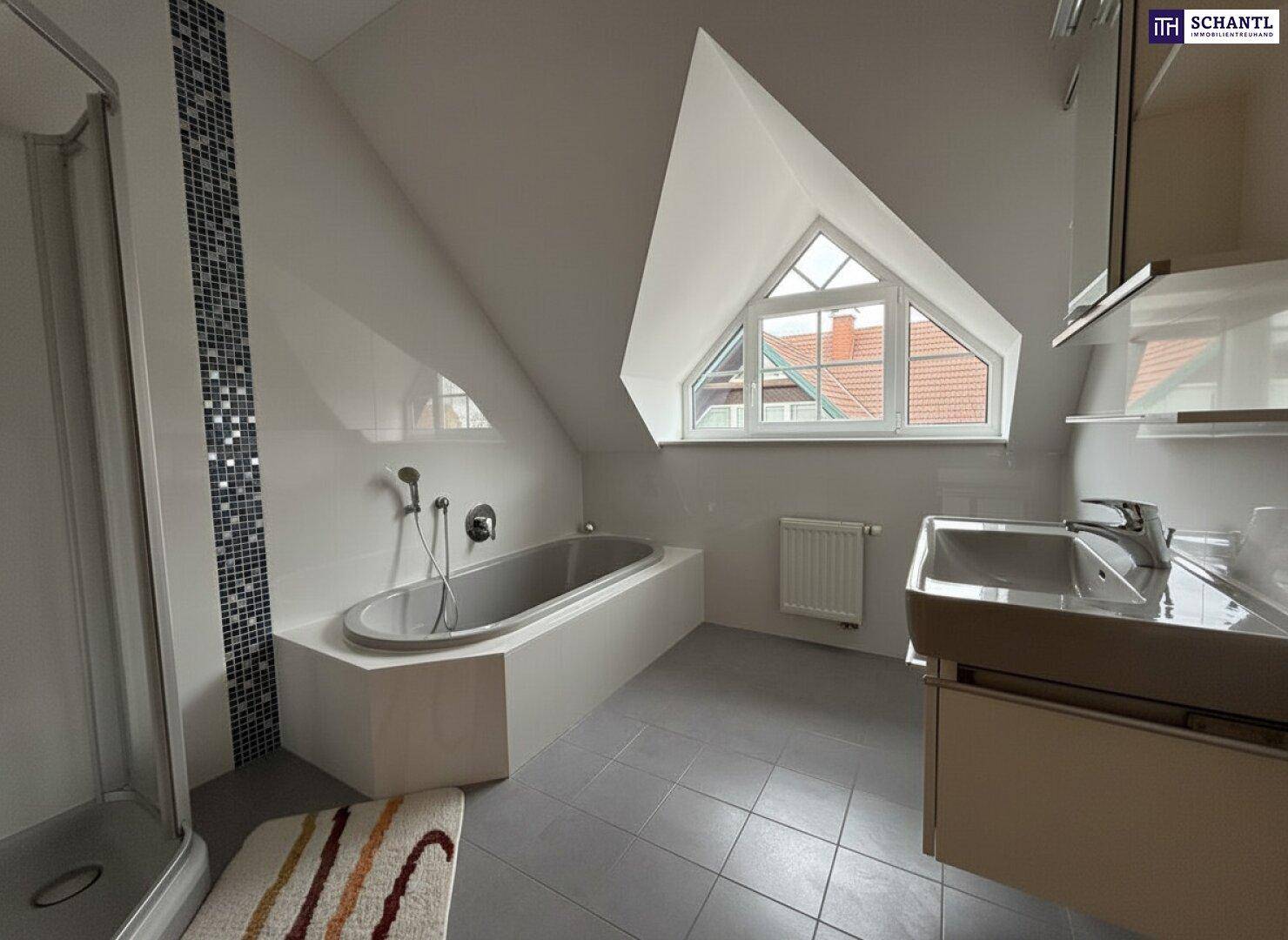 Modernes Badezimmer im Dachgeschoss mit Badewanne, Dusche und stilvollem Waschtisch.
