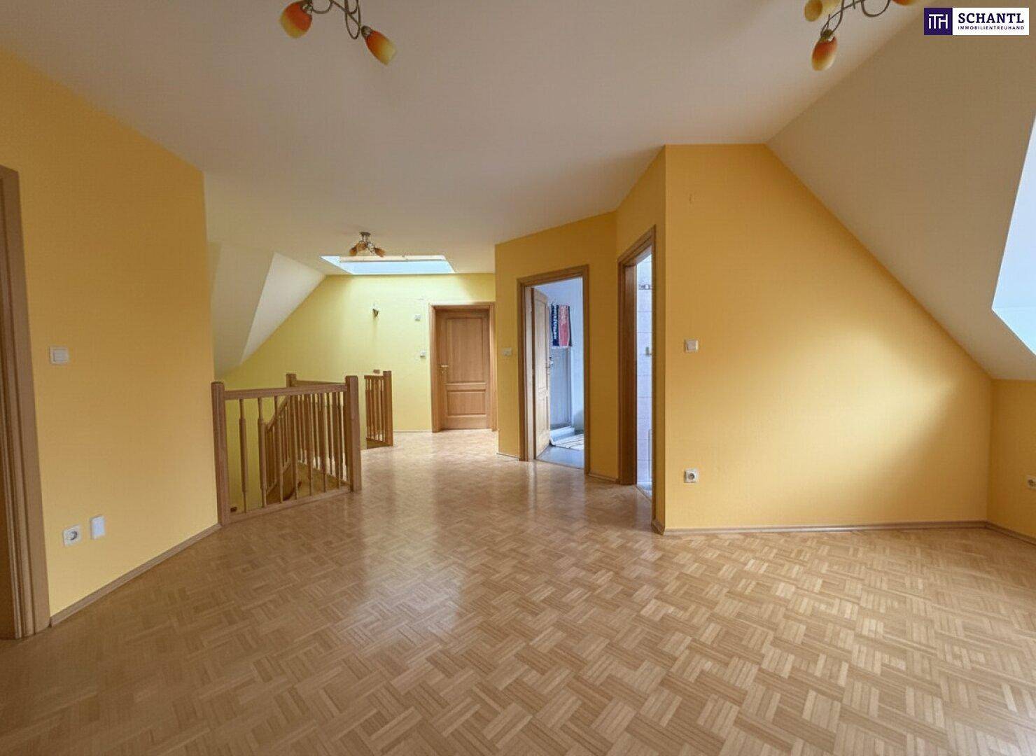 Offene Galerie im Obergeschoss mit Parkettboden, Dachschrägen und viel natürlichem Licht durch ein Dachfenster.