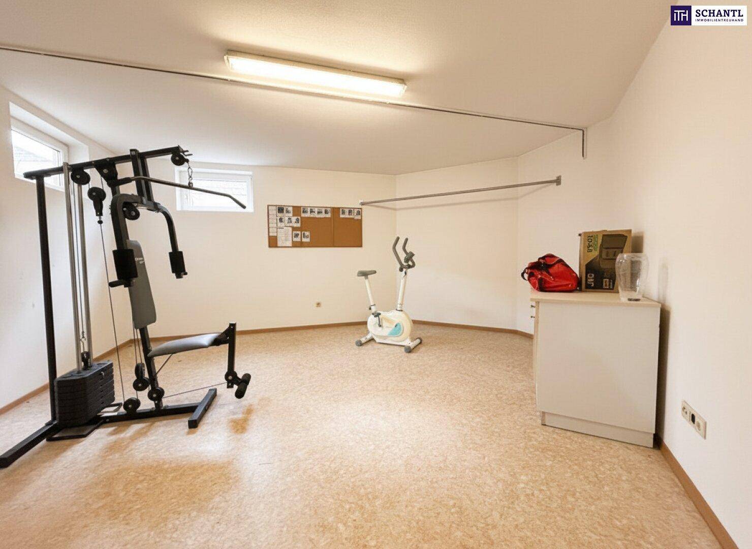 Hobbyraum im Keller, eingerichtet als Fitnessbereich mit Trainingsgeräten und Korkboden.