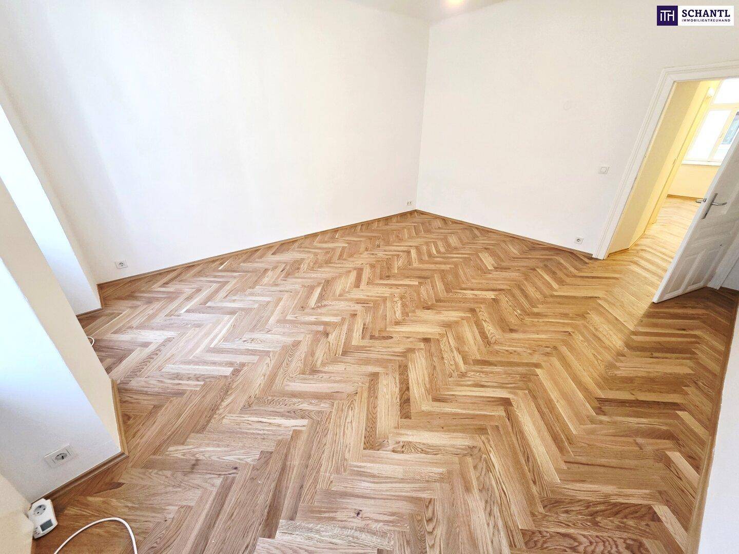 Heller Raum mit klassischem Fischgrätparkett und Zugang zu einem weiteren Zimmer, das vielseitig nutzbar ist.