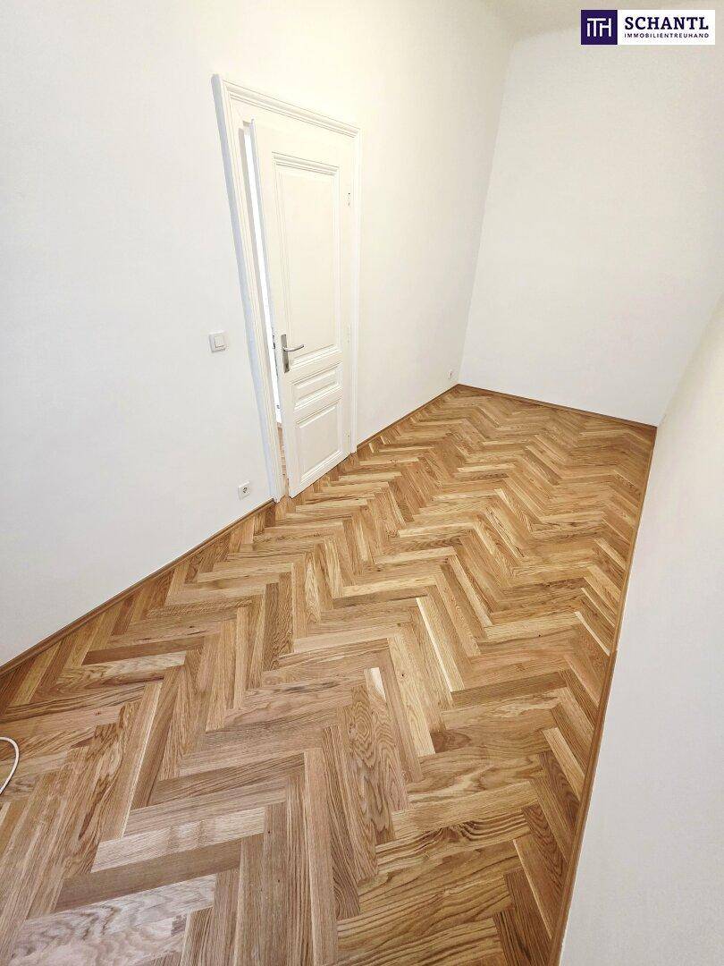 Leeres Zimmer mit Fischgrätparkett und weiß gestrichenen Wänden, ideal für individuelle Gestaltung.