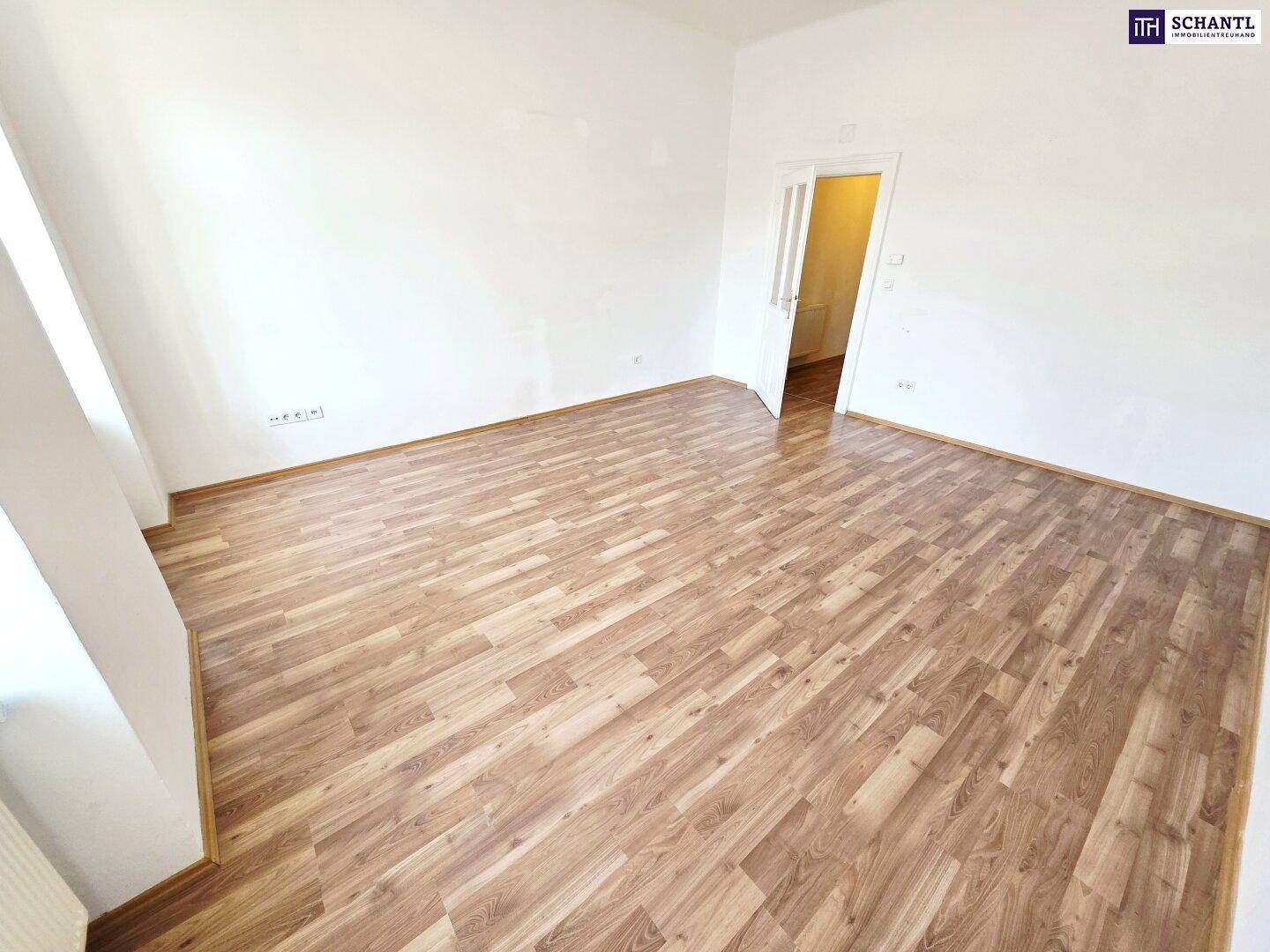 Helles Zimmer mit Laminatboden und weiß gestrichenen Wänden, bereit zur individuellen Gestaltung.